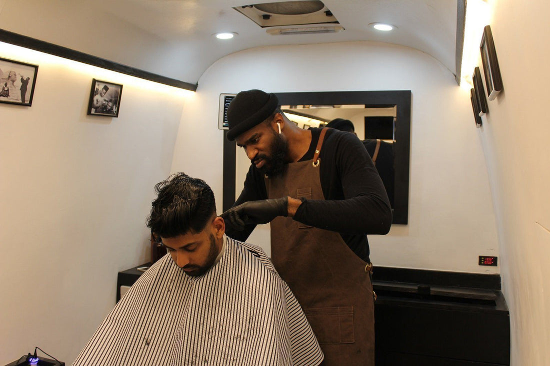 Photo of a man doing haircut to another a man