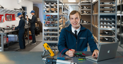 Progressive Automations team member providing technical support in warehouse with linear actuators and components.